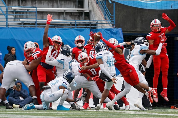 The Class 3A football championship last month spurred the debate over using instant replay to review officials’ calls. Sandy Creek (in red) beat Cedar Grove (in white) 21-17 after scoring the winning touchdown on a third-down run that GPB Sports replays showed was stopped short of the goal line. In the photo above, a kick is blocked. (Jason Getz/The Atlanta Journal-Constitution)