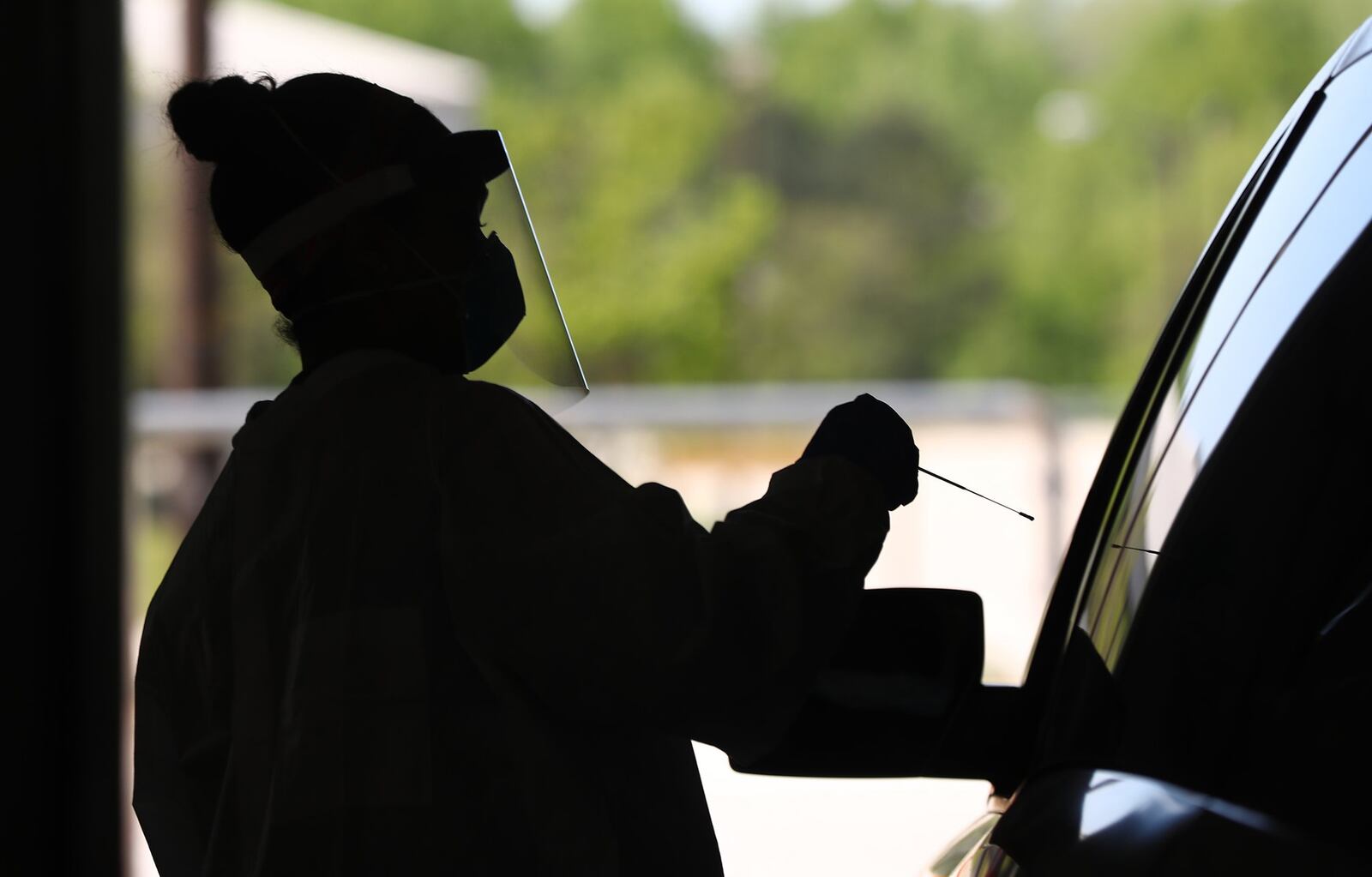 In this file photo, Emory Hospital registered nurse Aisha Bennett takes a nasal swab test for COVID-19 in a drive through site at the Georgia International Horse Park.(CURTIS COMPTON/CURTIS.COMPTON@AJC.COM)