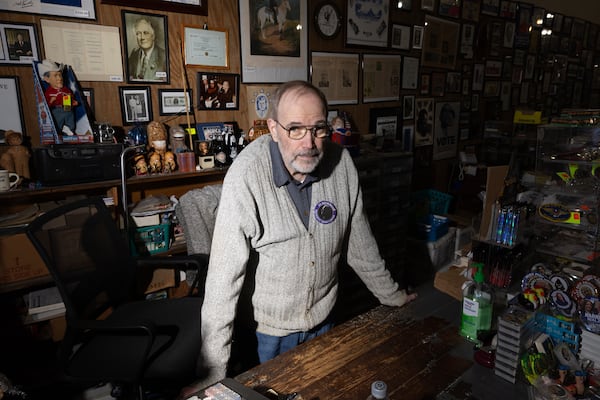 Philip Kurland has sold political campaign memorabilia out of his Plains Trading Post for more than 30 years. Most of what he sells are campaign buttons. All original, dating back to Abraham Lincoln. On Monday, Kurland stood in the middle of his shop, wearing a gray sweater with a big new button attached: “In Memoriam – Jimmy Carter.” (Arvin Temkar / AJC)