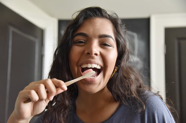 Hannah Testa, 16, uses her bamboo toothbrush at her home in Cumming. Testa is an environmental activist who recently spoke in favor of the bill that would ban single-use plastics in Fulton County buildings. She began speaking out about plastic pollution at age 10 after viewing a documentary that featured the Great Pacific Garbage Patch, the massive island of plastic that floats on the Pacific Ocean between Hawaii and California. HYOSUB SHIN / HSHIN@AJC.COM