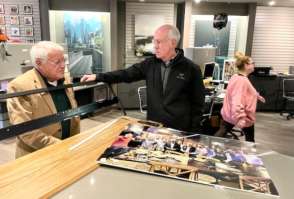 Chuck Wolf, longtime photo guy, left, speaks with customer Martin Tilson at his store.