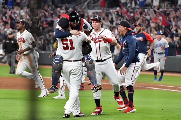 Braves catcher Travis d'Arnaud jumps into the arms of relief pitcher Will Smith (51) after the final out. Hyosub Shin / Hyosub.Shin@ajc.com