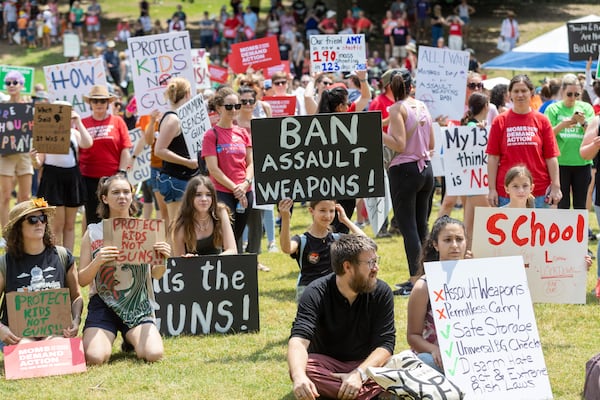 People hold up signs at a rally organized by Georgia Moms Demand Action in Piedmont Park Saturday, May 13, 2023. The rally was part of a national series of protests the day before Mother’s Day to highlight the mounting toll of gun violence.  (Steve Schaefer/steve.schaefer@ajc.com)