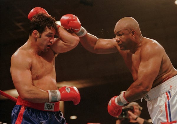 FILE - Lou Savarese of New York City blocks a right from George Foreman during their scheduled 12 round bout at the Atlantic City Convention Hall in Atlantic City, N.J., Saturday, April 26, 1997. (AP Photo/B.Vartan Boyajian, File)