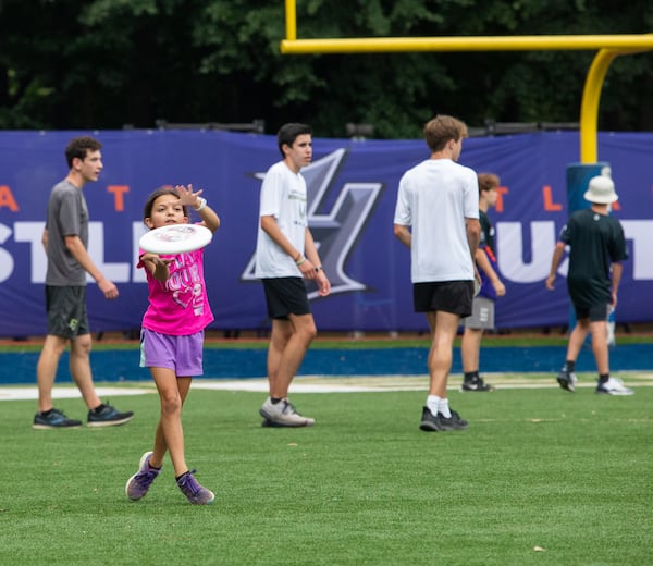 During halftime, fans, including 9-year-old Estee Litner, in pink, are allowed to come onto the field to toss a disc with the professionals.  The Hustle, Atlanta's American Ultimate Disc League team, competed against Philadelphia at St. Pius X High School Field on Saturday, June 26, 2021. Atlanta won the game 24-17.  (Jenni Girtman for The Atlanta Journal-Constitution)