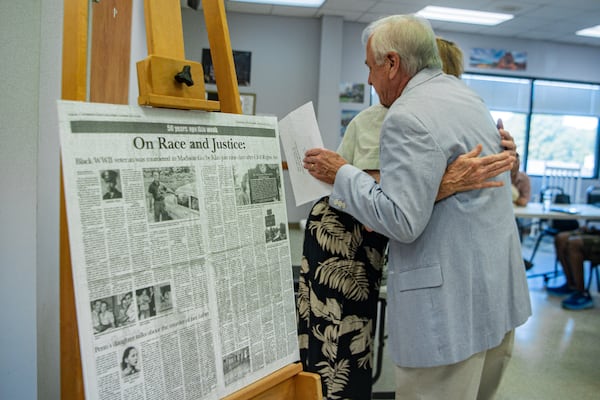 Dena Chandler, (left), hugs David Sweat, senior superior court judge of Western Judicial Circuit during the Lemuel Penn remembrance ceremony in Madison County on Thursday, July 11, 2024. At left are news pages from The Madison County Journal about the the case. (Ziyu Julian Zhu / AJC)