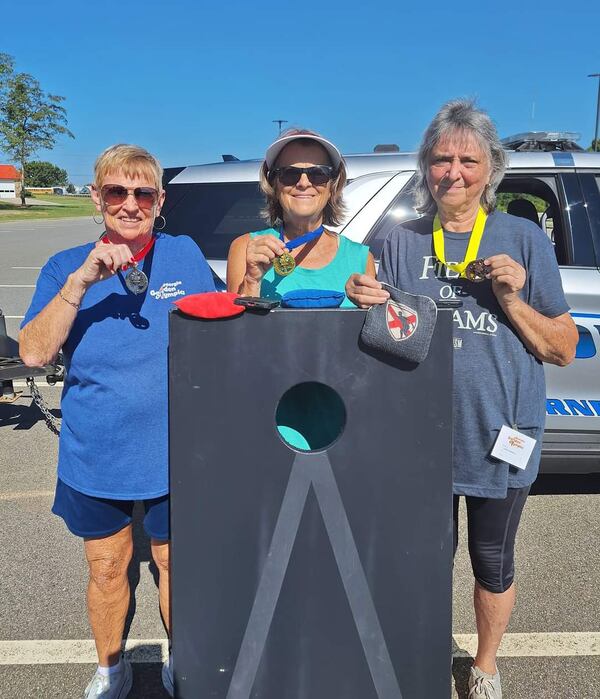 Gladys Mixon and Carol Waddell flank their competitor as the proudly display the silver and bronze medals they won in Cornhole competition. The women, now in their 70s, have been friends since they were 16 years old and see the Georgia Golden Olympics as just another adventure they can tackle together. (Courtesy of Gladys Mixon)