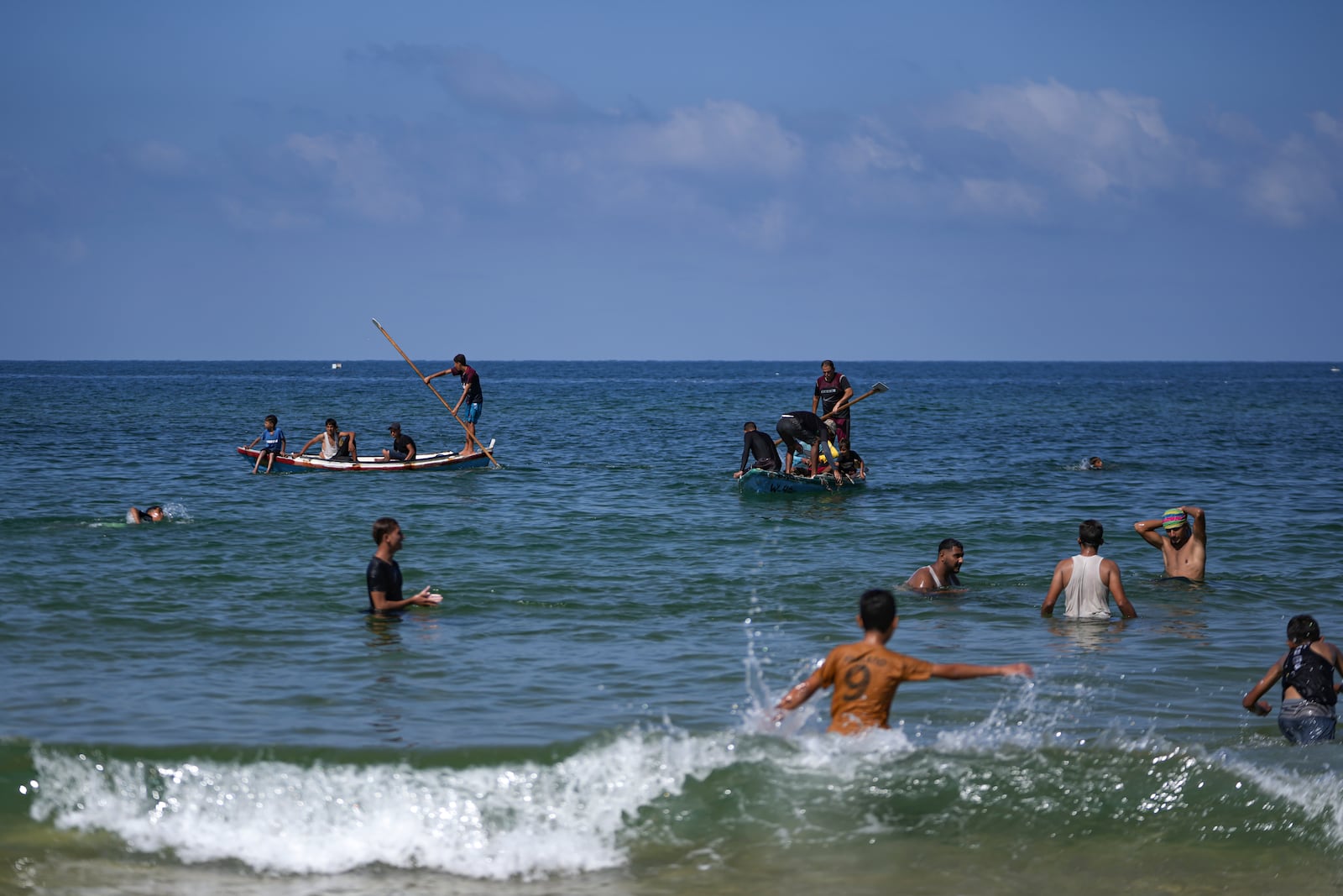 Palestinians displaced by the Israeli air and ground offensive on the Gaza Strip, enjoy the day on the beach of Deir al-Balah, Wednesday, Oct. 9, 2024. (AP Photo/Abdel Kareem Hana)