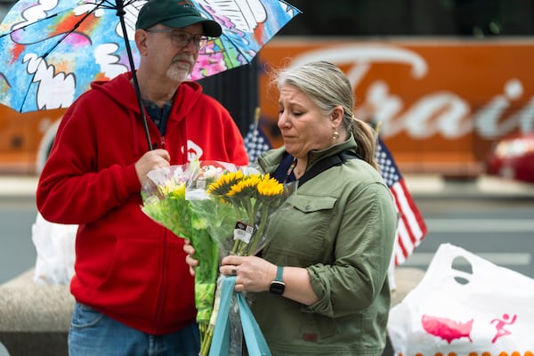 A United States Agency for International Development (USAID) worker holds a bouquet of flowers given to her after retrieving her personal belongings from USAID's headquarters in Washington, Thursday, Feb. 27, 2025. (AP Photo/Manuel Balce Ceneta)