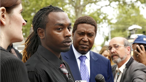 Nandi Cain Jr., left, answers a reporter's question during an April 24, 2017, news conference about the beating he received two weeks before from a Sacramento police officer who accused him of jaywalking. His attorney, John Burris, in blue suit, said last week that Cain has reached a $550,000 settlement with the city that will also bring about police procedural changes.