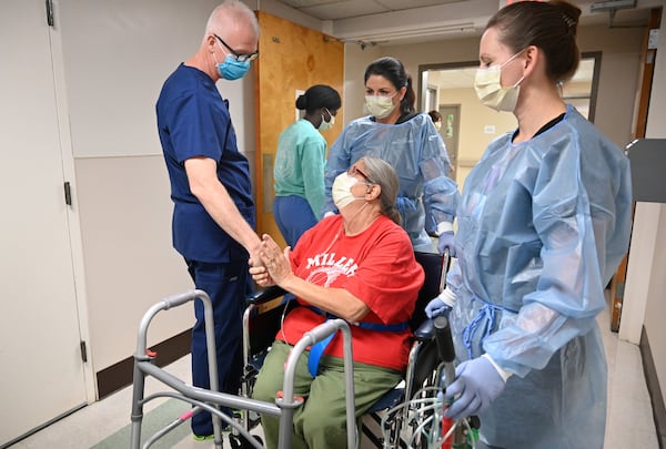 Glenda Bailey, Miller County resident who had COVID-19, thanks Dr. Bill Swofford, left, as she is assisted by medical staff Carmen Lambert and Jamie Middleton, right, at Miller County Hospital on Monday. Months ago, when Bailey's COVID-19 infection became life-threatening, she had been transferred to a larger hospital. After she was able to breathe on her own, she was brought back to Miller County.(Hyosub Shin / Hyosub.Shin@ajc.com)