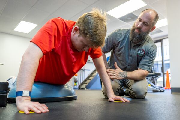 Coach Dustin Dalton (right) works with Davis Manton at the ReClif fitness-based therapy center in Peachtree Corners Tuesday, Feb. 14, 2023.  (Steve Schaefer/steve.schaefer@ajc.com)