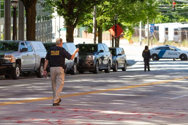 The road in front of the DHS/ICE field office is searched for evidence Sunday, July 26, 2020, after being vandalized. STEVE SCHAEFER FOR THE ATLANTA JOURNAL-CONSTITUTION