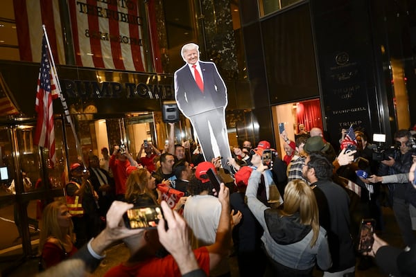 
                        People raise a cardboard cutout of Former President Donald Trump, the Republican presidential nominee, outside of Trump Tower, in New York, on Wednesday, Nov. 6, 2024. New York City Is Still a Democratic Town but Trump Made Inroads; the rightward shift in the presidential election results was especially pronounced among Asian voters and Hispanic voters in Queens and the Bronx. (Karsten Moran/The New York Times)
                      