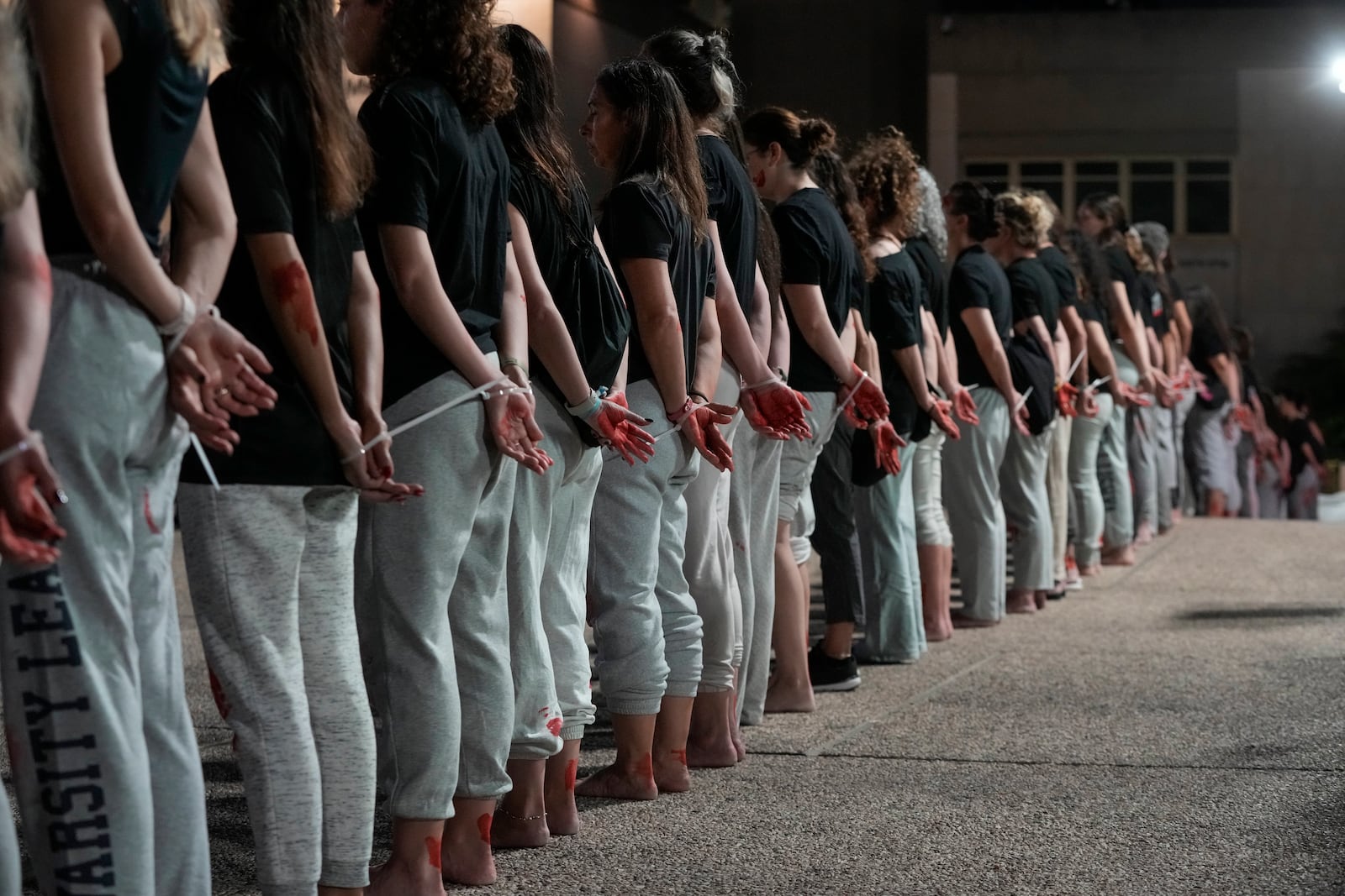 Women demonstrators take part in a performance calling for the release of hostage Naama Levy, held in the Gaza Strip by the Hamas militant group, in Tel Aviv, Israel, Saturday, Oct. 19, 2024. (AP Photo/Mahmoud Illean)