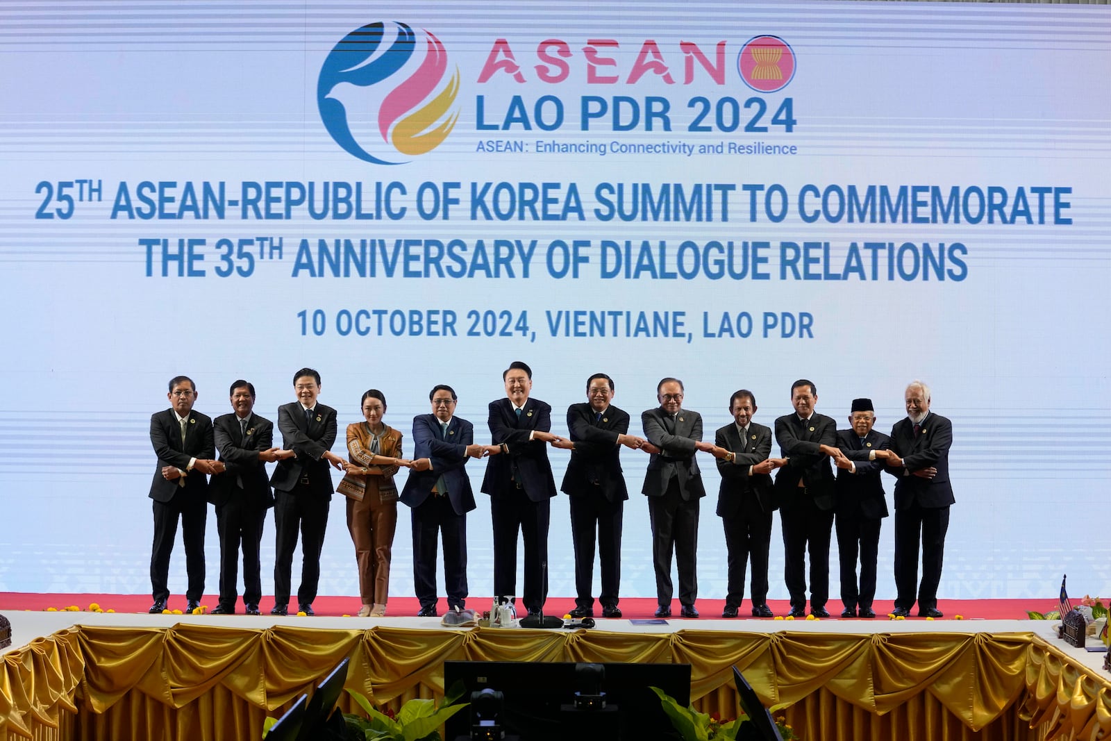 From left, Myanmar's Foreign Ministry Permanent Secretary Aung Kyaw Moe, Philippine's President Ferdinand Marcos Jr., Singapore's Prime Minister Lawrence Wong, Thailand's Prime Minister Paetongtarn Shinawatra, Vietnam's Prime Minister Pham Minh Chinh, South Korea President Yoon Suk Yeol, Laos' Prime Minister Sonexay Siphandone, Malaysia's Prime Minister Anwar Ibrahim, Brunei Sultan Hassanal Bolkiah, Cambodia's Prime Minister Hun Manet, Indonesia's Vice President Ma'ruf Amin, and East Timor's Prime Minister Xanana Gusmao hold hands for a group photo session during the 25th ASEAN - South Korea Summit to commemorate the 35th Anniversary of Dialogue Relation in Vientiane, Laos, Thursday, Oct. 10, 2024. (AP Photo/Sakchai Lalit)