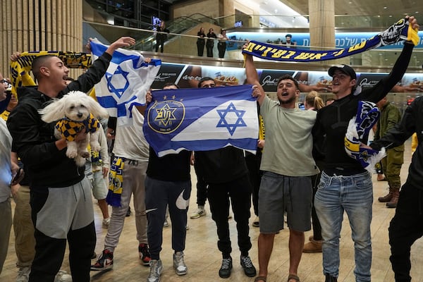 People welcome Maccabi Tel Aviv soccer fans as they arrive at Israel's Ben-Gurion International Airport on a flight from Amsterdam, where Israeli soccer fans were attacked following a match between the Israeli club and Ajax Amsterdam, in Lod, Israel, Friday, Nov. 8, 2024. (AP Photo/Tsafrir Abayov)