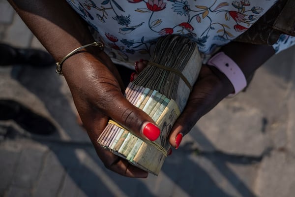 A currency exchanger waits for customers in downtown Goma, Democratic Republic of Congo, Thursday, Feb. 27, 2025, one month after Rwanda-backed M23 rebels captured the city. (AP Photo/Moses Sawasawa)