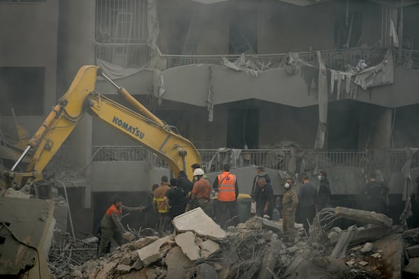 Rescue workers and people search for victims at the site of an Israeli airstrike that hit central Beirut, Lebanon, Saturday, Nov. 23, 2024. (AP Photo/Hassan Ammar)