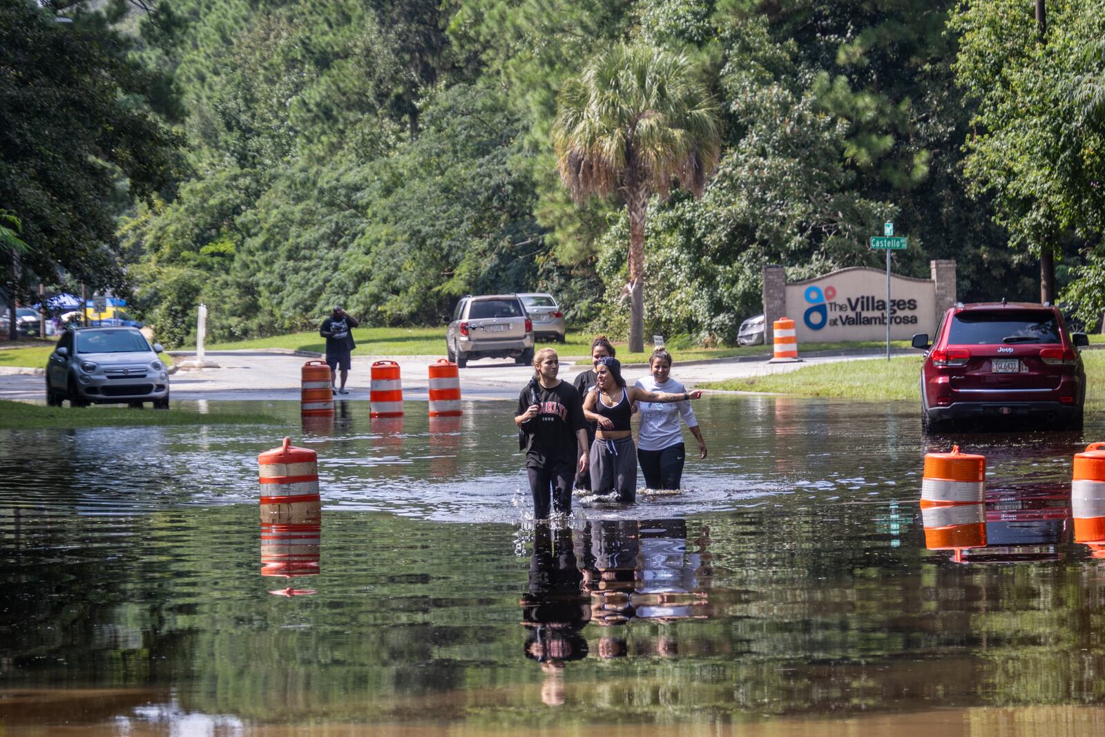 A group of people walk through a flooded road on Bradley Boulevard on Monday, August 12, 2024, in Savannah, Ga. (AJC Photo/Katelyn Myrick)