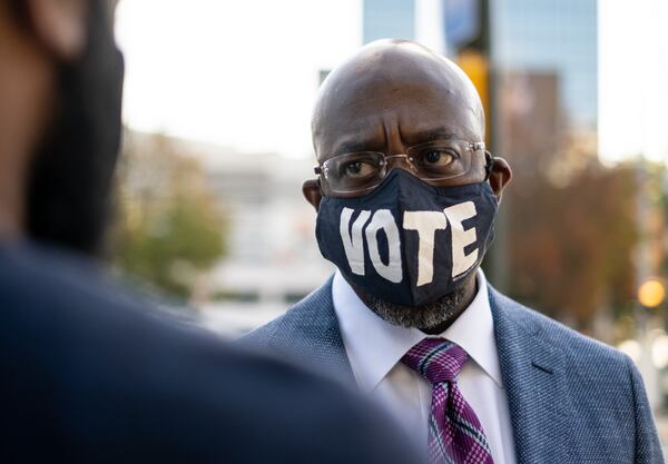 201021-Atlanta- Rev. Raphael Warnock talks with a member of his campaign staff before voting Wednesday morning, October 21, 2020 at State Farm Arena in downtown Atlanta. Ben Gray for the Atlanta Journal-Constitution