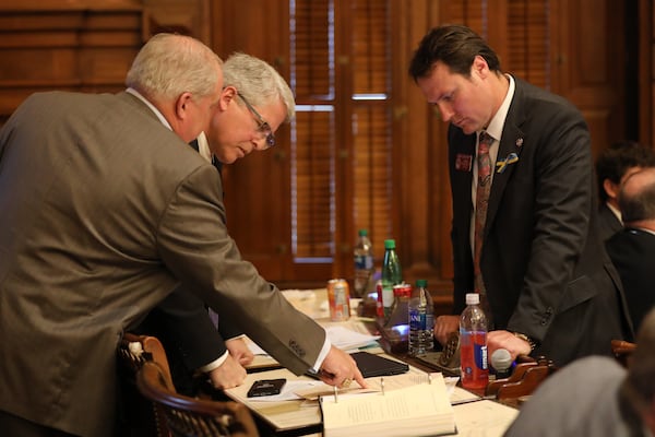 State Rep. Chuck Martin (left) talks Tuesday to state Rep. James Burchett, sponsor of House Bill 1464, and state Rep. Stan Gunter, chairman of the Elections Integrity Committee. This bill builds on last year's elections measure that limited drop boxes, required more voter ID for absentee voting, and allowed state takeovers of county election boards. Miguel Martinez for The Atlanta Journal-Constitution 