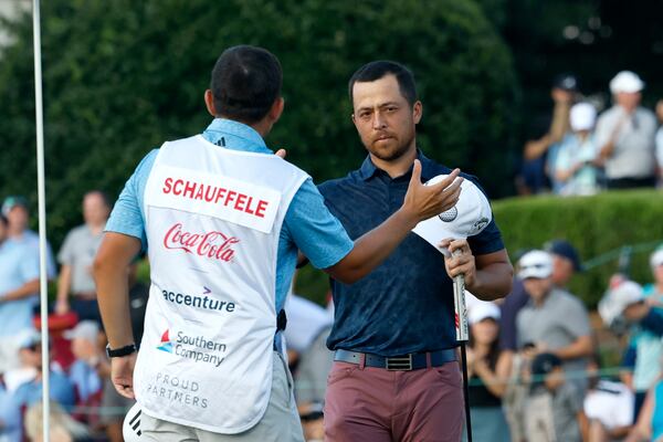 Xander Schauffele greets his caddie Austin Kaiser after their round on the eighteenth hole during the second round of the Tour Championship at East Lake Golf Club, Friday, August 26, 2022, in Atlanta. (Jason Getz / Jason.Getz@ajc.com)