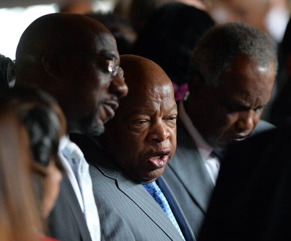 Sen. Raphael Warnock, pastor of Ebenezer Baptist Church, and the late Congressman John Lewis chat during a 2014 political rally in Atlanta.  