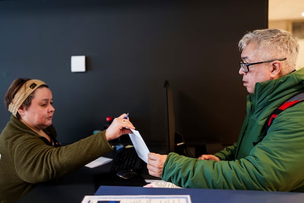 Carl Fleischer, 59, receives his ballot during an early voting for Greenlandic parliamentary elections at the city hall in Nuuk, Greenland, Monday, March 10, 2025. (AP Photo/Evgeniy Maloletka)