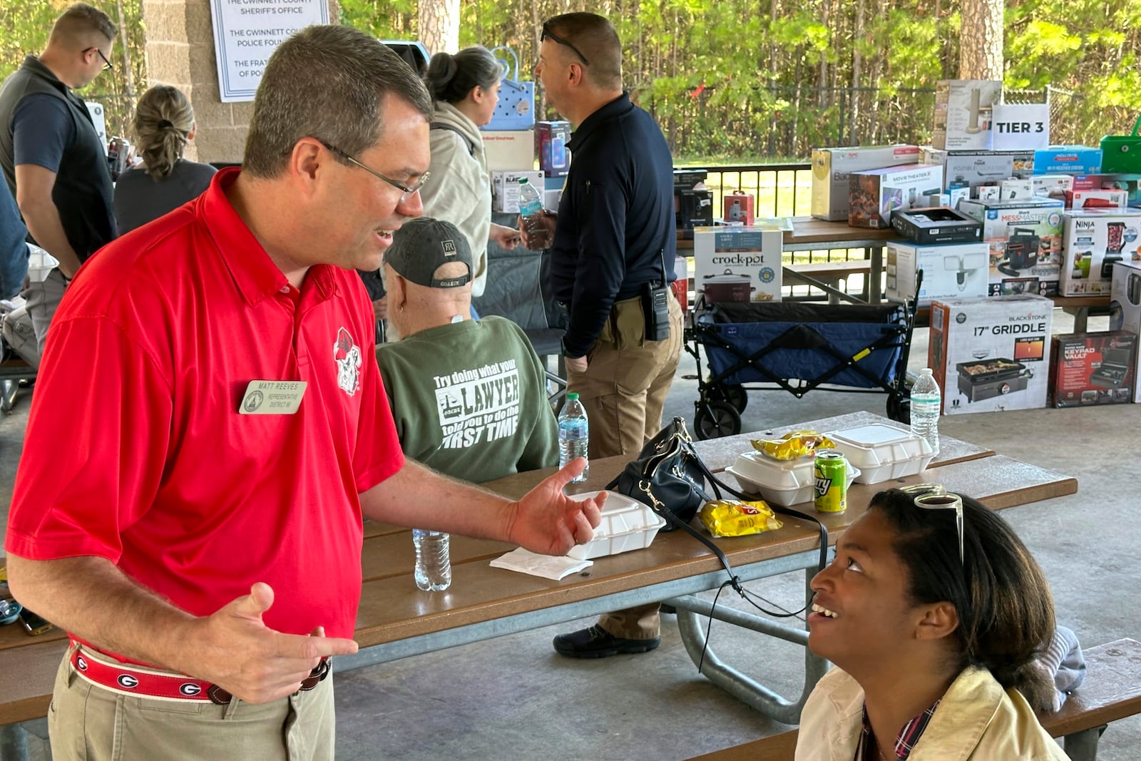 Georgia state Rep. Matt Reeves, R-Duluth, speaks to an organizer of a law enforcement appreciation picnic in Lawrenceville, Ga., Saturday, Oct. 19, 2024. (AP Photo/Jeff Amy)