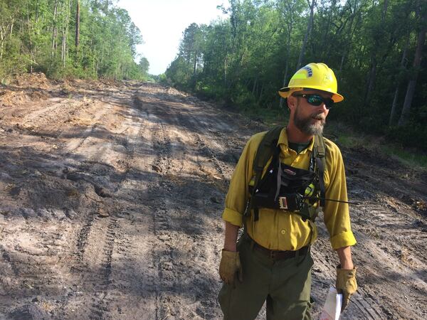 May 11, 2017 — Joe Zwierzchowski, a spokesman for the agencies battling the blaze, stands in an area cut to stop flames. (Craig Schneider / Craig.Schneider@ajc.com)