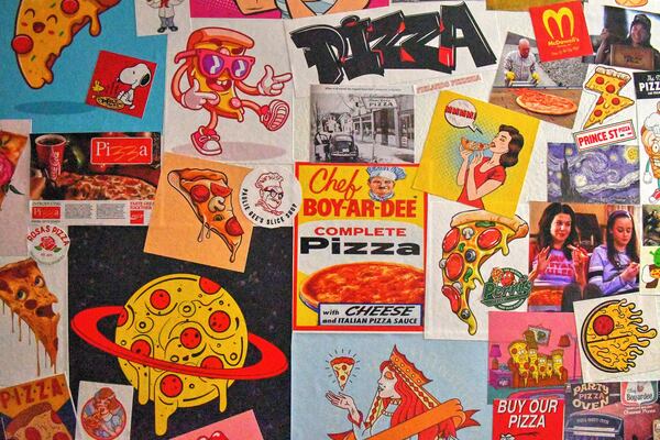 Floor-to-ceiling pizza-related stickers cover the bathroom's walls at Pielands Sub & Slice. (Chris Hunt for The Atlanta Journal-Constitution)