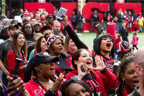 A cheering crowd lines up to get into the Falcons Rise Up Rally at Atlantic Station the day before the Falcons faced the Packers in the conference championship game Sunday. (Steve Schaefer / For The AJC)