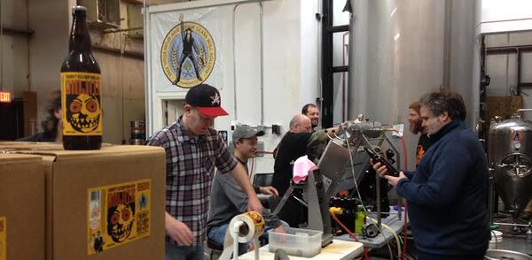 The crew at Burnt Hickory Brewery in Kennesaw bottles the Didjits Blood Orange IPA, with owner-brewmaster Scott Hedeen (right). Contributed.