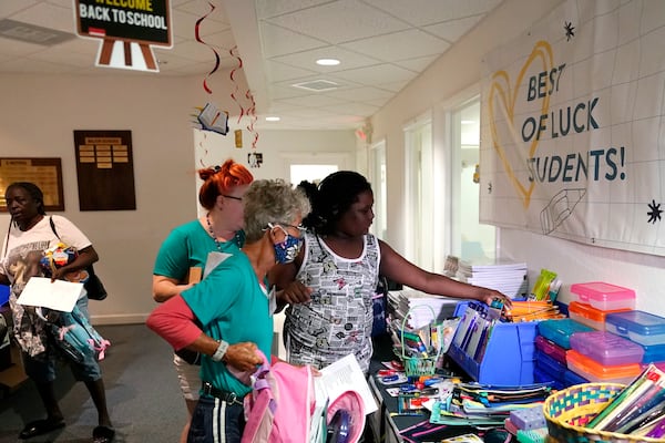 FILE - Aaliyah Floyd, 10, right, selects school supplies with volunteer Cindy Blomquist, left, at the annual Back to School Distribution Day at The Pantry, Friday, July 29, 2022, in Fort Lauderdale, Fla. The Pantry works with grandparents who are the primary caregivers for their grandchildren, offering free backpacks, lunch boxes, school supplies and sneakers. (AP Photo/Lynne Sladky, File)