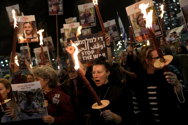 Relatives and friends of people killed and abducted by Hamas and taken into Gaza, react to the ceasefire announcement as they take part in a demonstration in Tel Aviv, Israel, Wednesday, Jan. 15, 2025. (AP Photo/Oded Balilty)