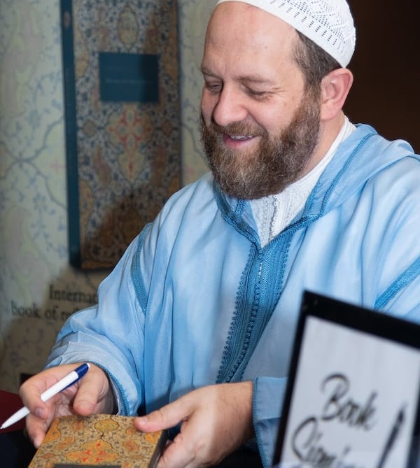 Sheikh Muhammad al-Ninowy, founder of the Madina Institute in Duluth, signed copies of his book Sunday at The Carter Center. SARA ABUGIDEIRI / WESTERLY PHOTOGRAPHY