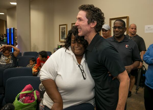 Pastor Joel Osteen hugs evacuee Uranda Adigun at an emergency shelter at Lakewood Church in Houston after Hurricane Harvey on Tuesday August 29, 2017.  JAY JANNER / AMERICAN-STATESMAN