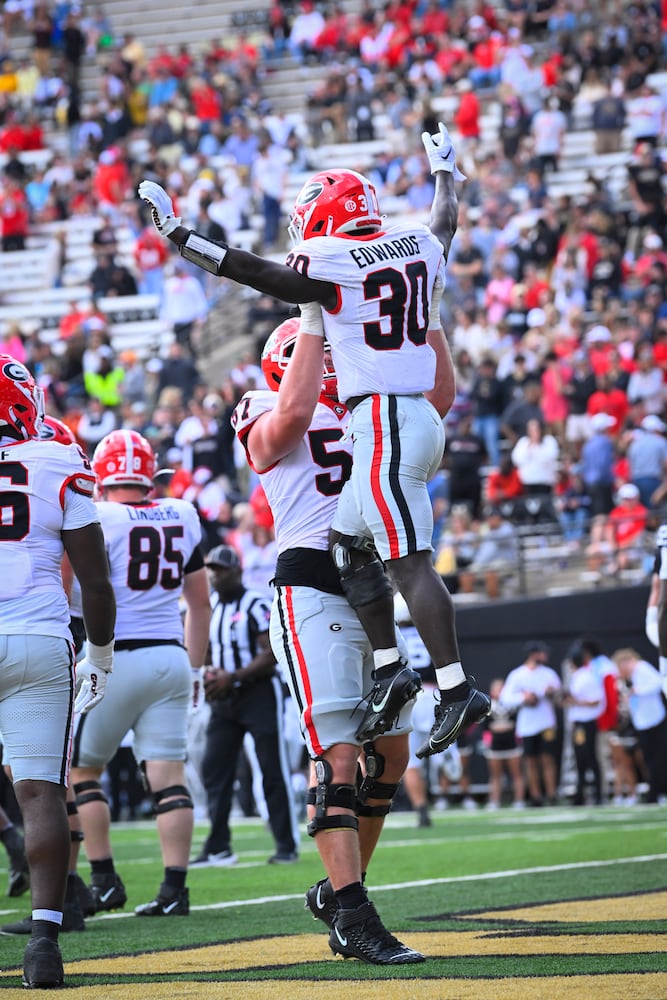 Georgia running back Daijun Edwards (30) is lifted by offensive lineman Monroe Freeling (57) after scoring against Vanderbilt during the second half of an NCAA football game, Saturday, Oct. 14, 2023, in Nashville, Tenn. Georgia won 37-20. (Special to the AJC/John Amis)