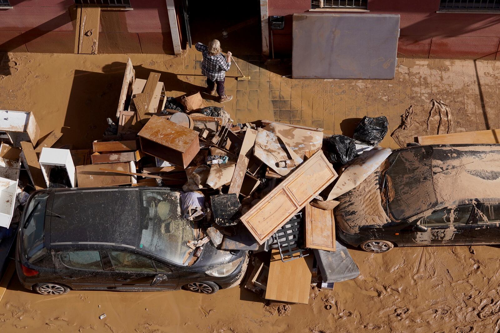 Residents clean their house affected by floods in Valencia, Spain, Thursday, Oct. 31, 2024. (AP Photo/Alberto Saiz)