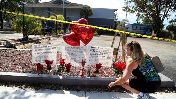 In this Thursday, Sept. 14, 2017 file photo, Janice Connelly of Hollywood, sets up a makeshift memorial in memory of the senior citizens who died in the heat at The Rehabilitation Center at Hollywood Hills, Fla. Multiple people died and patients had to be moved out of the facility, many of them on stretchers or in wheelchairs. Authorities have launched a criminal investigation to figure out what went wrong and who, if anyone, was to blame. (Carline Jean /South Florida Sun-Sentinel via AP, File)