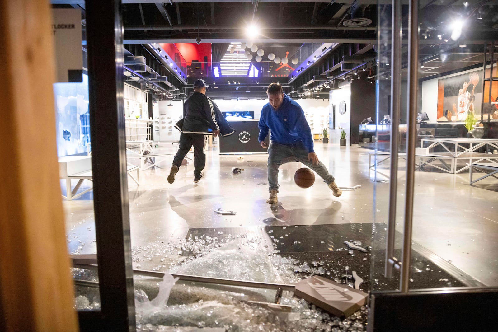 People are seen at a ransacked Nike store after the Los Angeles Dodgers defeated the New York Yankees to win the baseball World Series Wednesday, Oct. 30, 2024, in Los Angeles. (AP Photo/Ethan Swope)