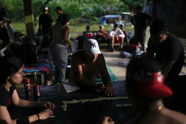 FILE - Venezuelan migrants play dominoes in Puerto Carti, on Panama's Caribbean coast, Feb. 22, 2025, where they plan to board boats to Colombia after turning back from southern Mexico where they gave up hopes of reaching the U.S. amid President Trump's crackdown on migration. (AP Photo/Matias Delacroix)