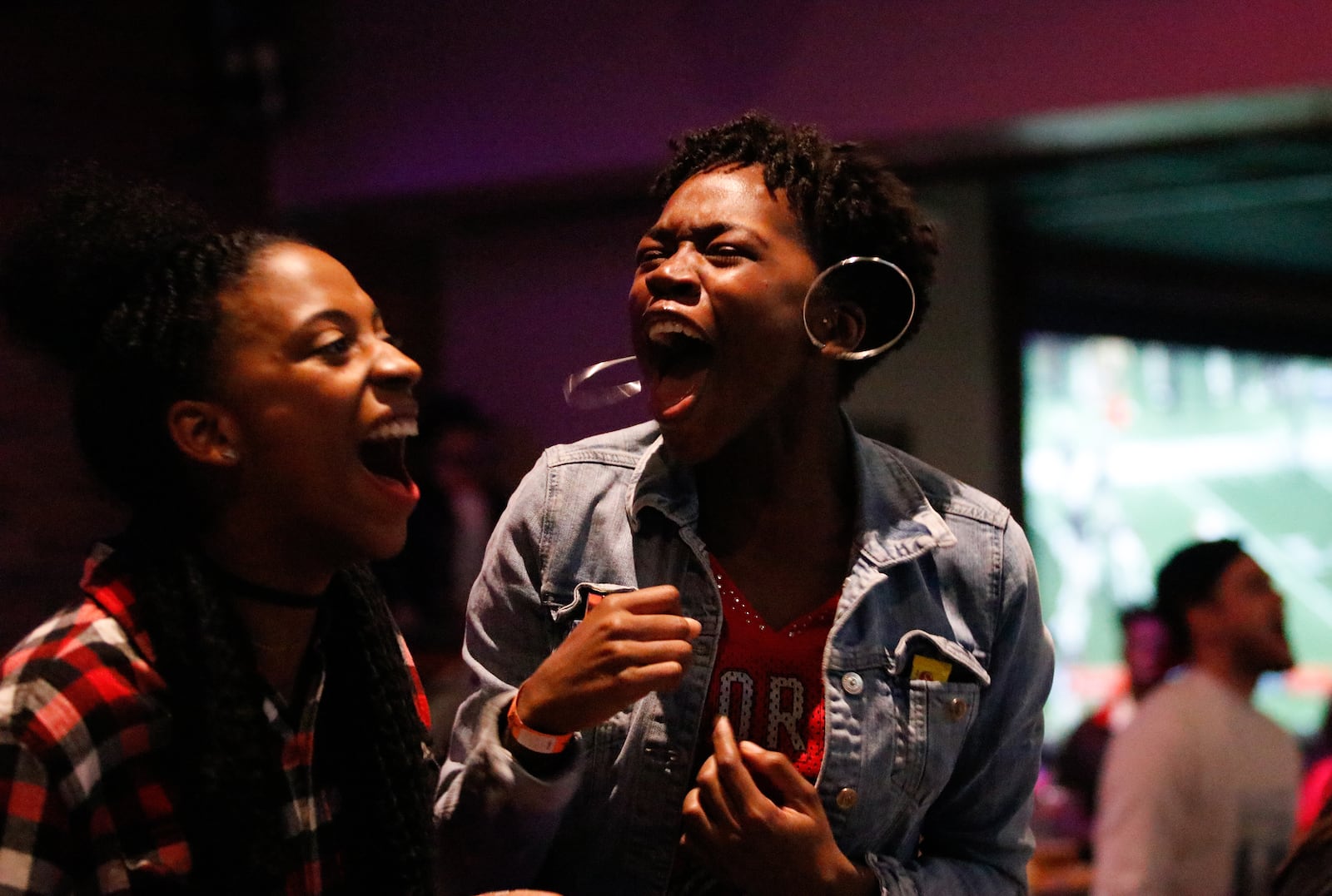 University of Georgia students Jerilyn Williamson (left) and Mikaela Gay cheer on the Bulldogs during the SEC championship football game against Auburn on Saturday, Dec. 2, 2017, while watching at Jerzee's Sports Bar in Athens. 