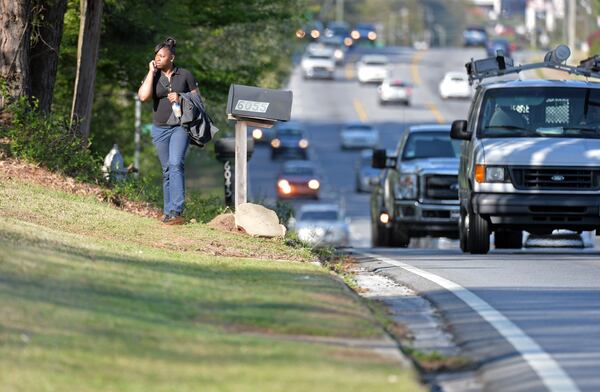 Alberta Watson walks along Lawrenceville Highway in Gwinnett County on April 9, 2014, one of several roads that could get sidewalks in the latest round of 2014 SPLOST funding. HYOSUB SHIN / HSHIN@AJC.COM