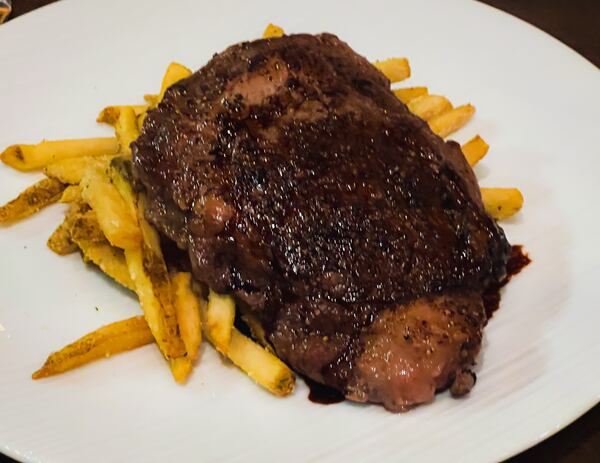 The 10-ounce rib-eye steak at Palm 78 is served on top of a mound of Parmesan fries. Henri Hollis/henri.hollis@ajc.com