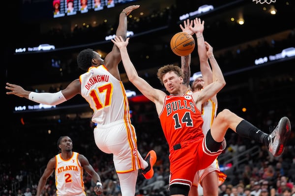 Chicago Bulls forward Matas Buzelis (14) loses control of the bll as he tries to go between Atlanta Hawks' Garrison Mathews (24) and Onyeka Okongwu (17) during the first half of an NBA basketball game Saturday, Nov. 9, 2024, in Atlanta. (AP Photo/ John Bazemore)