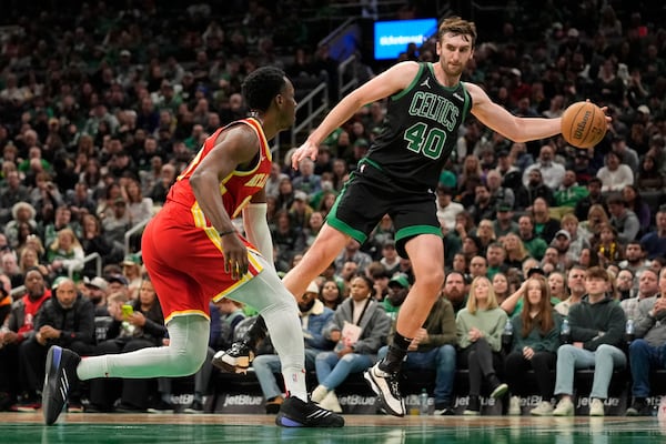 Boston Celtics' Luke Kornet (40) looks to pass the ball while defended by Atlanta Hawks' Onyeka Okongwu, left, during the first half of an NBA basketball game, Saturday, Jan. 18, 2025, in Boston. (AP Photo/Robert F. Bukaty)