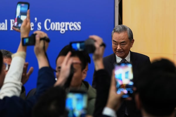 Chinese Foreign Minister Wang Yi reacts to journalists as he leaves a press conference on the sideline of the National People's Congress in Beijing, Friday, March 7, 2025. (AP Photo/Ng Han Guan)