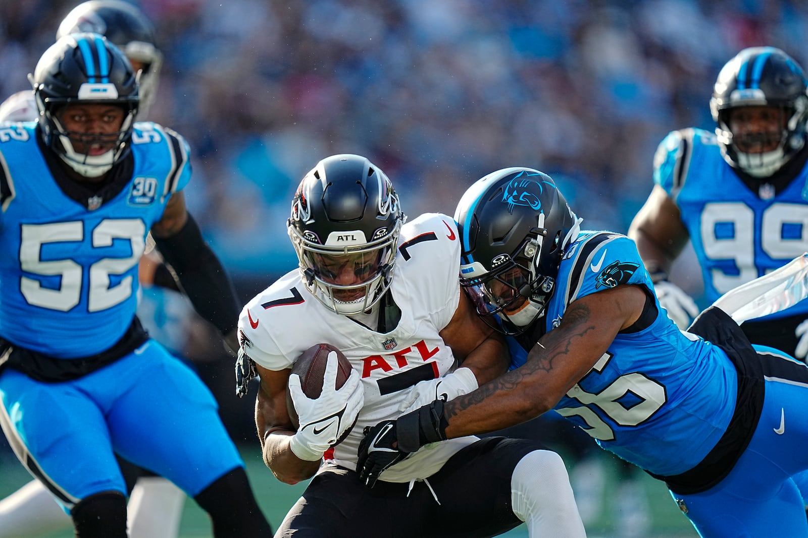 Atlanta Falcons running back Bijan Robinson (7) is tackled by Carolina Panthers linebacker Trevin Wallace (56) in the first half of an NFL football game in Charlotte, N.C., Sunday, Oct. 13, 2024. (AP Photo/Rusty Jones)